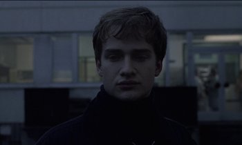 Movie still from “71 Fragments of a Chronology of Chance” (1994), directed by Michael Haneke – A young man with his eyes wide open in the dark; Close Up shot, Low angle