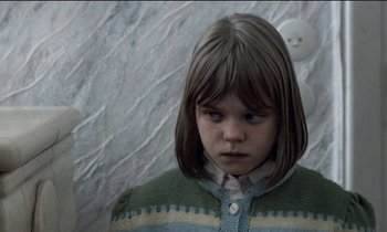 Movie still from “71 Fragments of a Chronology of Chance” (1994), directed by Michael Haneke – A young girl in a green and white sweater; Close Up shot, Over the shoulder angle
