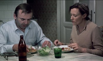 Movie still from “71 Fragments of a Chronology of Chance” (1994), directed by Michael Haneke – A man and a woman sitting at a dinner table; Medium shot, High angle
