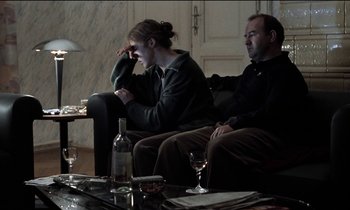 Movie still from “71 Fragments of a Chronology of Chance” (1994), directed by Michael Haneke – A man and a woman sitting on a couch; Medium shot, Over the shoulder angle