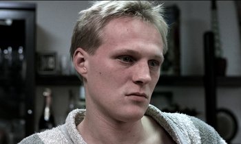 Movie still from “71 Fragments of a Chronology of Chance” (1994), directed by Michael Haneke – A person wearing a sweater; Close Up shot, Low angle