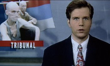Movie still from “71 Fragments of a Chronology of Chance” (1994), directed by Michael Haneke – A man standing in front of a television screen; Extreme Close Up shot, High angle