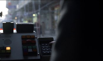 Movie still from “71 Fragments of a Chronology of Chance” (1994), directed by Michael Haneke – A person holding a calculator in front of a computer keyboard; Extreme Close Up shot, Over the shoulder angle