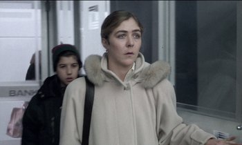 Movie still from “71 Fragments of a Chronology of Chance” (1994), directed by Michael Haneke – A woman in a white coat and a boy in a black jacket; Close Up shot, Over the shoulder angle