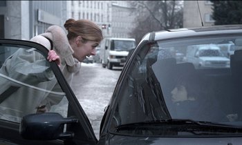 Movie still from “71 Fragments of a Chronology of Chance” (1994), directed by Michael Haneke – A woman looking into the window of a parked car; Medium shot, Over the shoulder angle