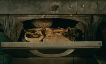 Movie still from “7 Rm., kit., ba...” (1984), directed by Agnès Varda – A bunch of food that is sitting in a metal box; Extreme Close Up shot, Overhead angle