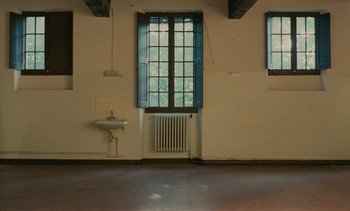 Movie still from “7 Rm., kit., ba...” (1984), directed by Agnès Varda – A room with a sink , radiator , and a window; Extreme Wide shot, High angle