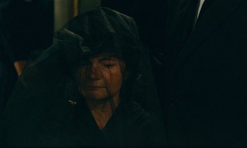 Movie still from “7 Rm., kit., ba...” (1984), directed by Agnès Varda – A woman with a black veil over her face; Close Up shot, Over the shoulder angle