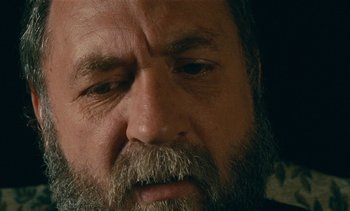 Movie still from “7 Rm., kit., ba...” (1984), directed by Agnès Varda – An old man with a beard and a mustache; Extreme Close Up shot, High angle