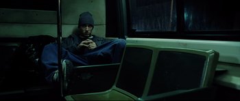 Movie still from “8 Mile” (2002), directed by Curtis Hanson – A man sitting on a train looking out of the window; Medium shot, High angle