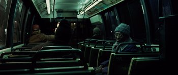 Movie still from “8 Mile” (2002), directed by Curtis Hanson – A person sitting on a bus with a hat on; Medium shot, Over the shoulder angle