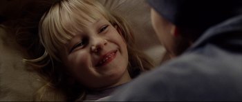 Movie still from “8 Mile” (2002), directed by Curtis Hanson – A little girl smiling for the camera while sitting in a chair; Close Up shot, Over the shoulder angle