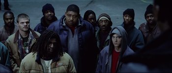 Movie still from “8 Mile” (2002), directed by Curtis Hanson – A group of men standing next to each other; Medium shot, Low angle