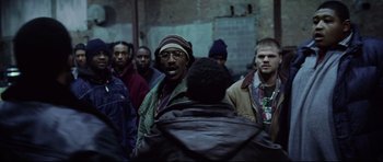 Movie still from “8 Mile” (2002), directed by Curtis Hanson – A group of men standing next to each other in a building; Medium shot, Over the shoulder angle