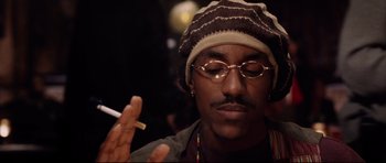 Movie still from “8 Mile” (2002), directed by Curtis Hanson – A man in a hat and glasses is smoking a cigarette; Close Up shot, Low angle