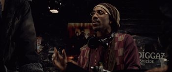 Movie still from “8 Mile” (2002), directed by Curtis Hanson – A man wearing a hat and glasses is listening to music; Close Up shot, Low angle