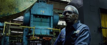 Movie still from “8 Mile” (2002), directed by Curtis Hanson – An older man wearing safety glasses in front of a machine; Close Up shot, Low angle