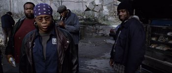 Movie still from “8 Mile” (2002), directed by Curtis Hanson – A group of men standing next to each other on a street; Medium shot, Over the shoulder angle