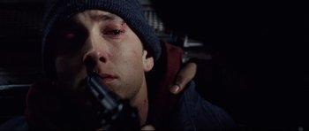 Movie still from “8 Mile” (2002), directed by Curtis Hanson – A man holding a gun while wearing a hat; Close Up shot, Low angle