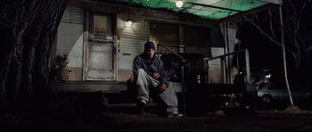 Movie still from “8 Mile” (2002), directed by Curtis Hanson – A man sitting on the steps of a house; Wide shot, Low angle