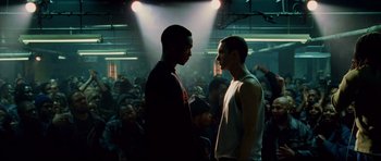 Movie still from “8 Mile” (2002), directed by Curtis Hanson – Two young men are facing each other in a crowd of onlookers; Medium shot, Over the shoulder angle