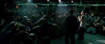 Movie still from “8 Mile” (2002), directed by Curtis Hanson – A group of people sitting in a dark room; Wide shot, High angle