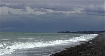 Movie still from “9 Songs” (2004), directed by Michael Winterbottom – A view of the ocean from the beach; Extreme Wide shot, Low angle