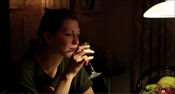Movie still from “9 Songs” (2004), directed by Michael Winterbottom – A woman holding a wine glass in her hand; Close Up shot, Over the shoulder angle