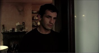 Movie still from “9 Songs” (2004), directed by Michael Winterbottom – A person wearing a black shirt; Close Up shot, Over the shoulder angle