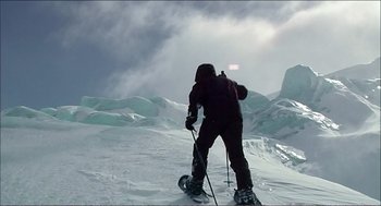 Movie still from “9 Songs” (2004), directed by Michael Winterbottom – A person on skis on a snowy slope; Wide shot, Low angle