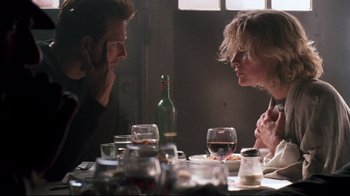 Movie still from “9½ Weeks” (1986), directed by Adrian Lyne – A man and a woman sitting at a dinner table; Medium shot, Over the shoulder angle