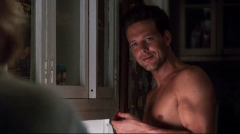 Movie still from “9½ Weeks” (1986), directed by Adrian Lyne – A shirtless man is looking at the camera; Close Up shot, Over the shoulder angle