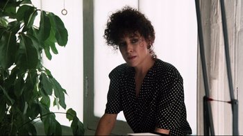 Movie still from “9½ Weeks” (1986), directed by Adrian Lyne – A woman sitting in front of a window; Medium shot, Low angle
