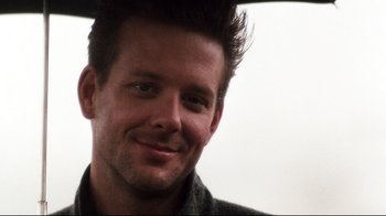 Movie still from “9½ Weeks” (1986), directed by Adrian Lyne – A person smiling for the camera; Close Up shot, Low angle