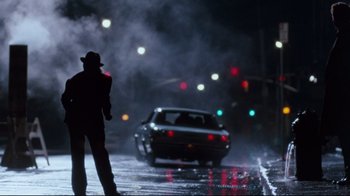 Movie still from “9½ Weeks” (1986), directed by Adrian Lyne – A man standing on the side of a road next to a car; Wide shot, Low angle