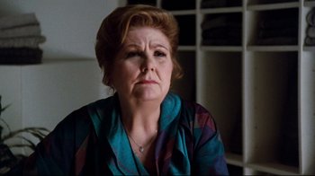 Movie still from “9½ Weeks” (1986), directed by Adrian Lyne – An older woman in a blue and purple shirt; Close Up shot, Over the shoulder angle