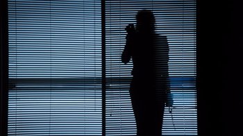 Movie still from “9½ Weeks” (1986), directed by Adrian Lyne – A woman standing in front of a window with blinds; Wide shot, Low angle