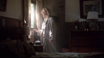 Movie still from “9½ Weeks” (1986), directed by Adrian Lyne – A woman standing next to a window in a room; Wide shot, Low angle