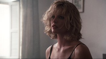 Movie still from “9½ Weeks” (1986), directed by Adrian Lyne – A woman with blonde hair is standing in a room; Close Up shot, Low angle