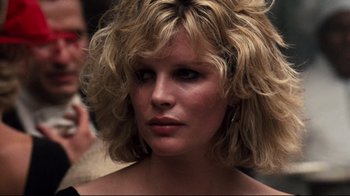 Movie still from “9½ Weeks” (1986), directed by Adrian Lyne – A person with blonde curly hair; Close Up shot, Over the shoulder angle