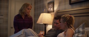 Movie still from “A Bad Moms Christmas” (2017), directed by Scott Moore – A man and a woman sitting in a bed next to another man; Medium shot, Over the shoulder angle