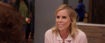 Movie still from “A Bad Moms Christmas” (2017), directed by Scott Moore – A woman with blonde hair sitting in front of a gray wall; Close Up shot, Over the shoulder angle