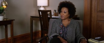 Movie still from “A Bad Moms Christmas” (2017), directed by Scott Moore – A woman sitting in a chair in front of a table; Close Up shot, Over the shoulder angle