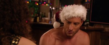 Movie still from “A Bad Moms Christmas” (2017), directed by Scott Moore – A shirtless man wearing a santa clause hat; Close Up shot, Over the shoulder angle