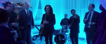 Movie still from “A Bad Moms Christmas” (2017), directed by Scott Moore – A group of people that are standing in a room with instruments; Wide shot, Over the shoulder angle