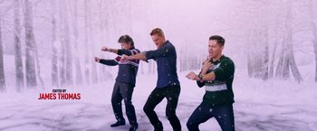 Movie still from “A Bad Moms Christmas” (2017), directed by Scott Moore – A group of young men standing on top of a snow covered field; Medium shot, High angle