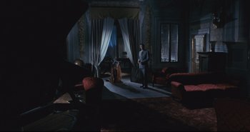 Movie still from “A Bay of Blood” (1971), directed by Mario Bava – A man and a woman standing in a living room; Wide shot, High angle