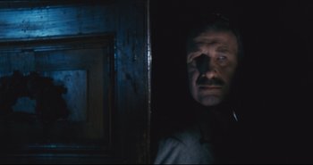 Movie still from “A Bay of Blood” (1971), directed by Mario Bava – A man in a dark room with his eyes wide open; Close Up shot, Low angle