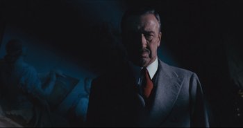 Movie still from “A Bay of Blood” (1971), directed by Mario Bava – A man in a suit and tie in a dimly - lit room; Close Up shot, Low angle