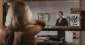 Movie still from “A Bay of Blood” (1971), directed by Mario Bava – A man and a woman in front of a mirror in a room; Medium shot, Low angle